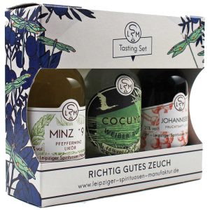 Ein Set mit drei kleinen Flaschen Pfefferminzlikör, Weißer Rum und Johannisbeerlikör in einer Geschenkbox